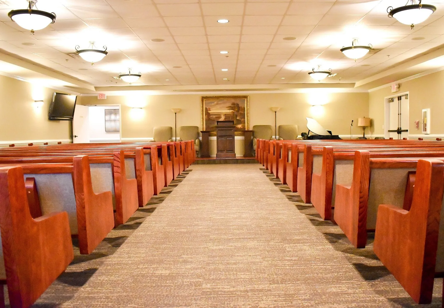 An empty church with rows of wooden benches and a podium