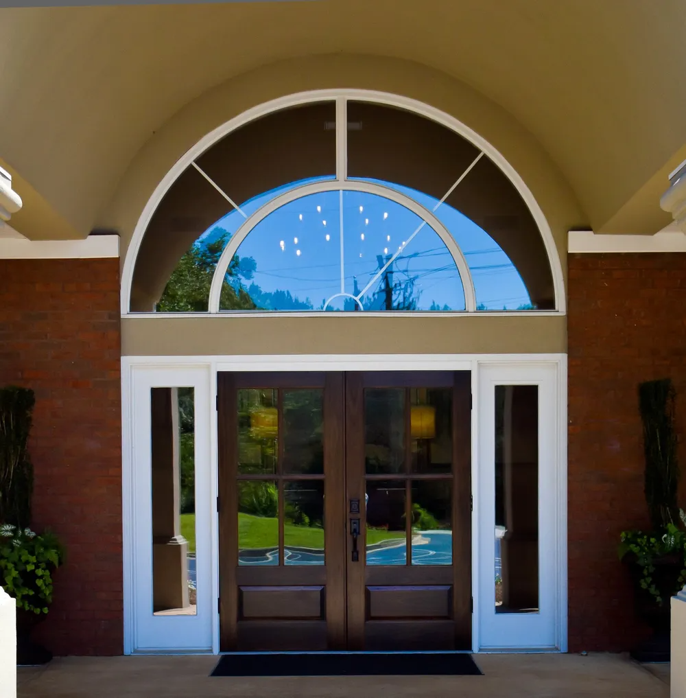 The front door of a building with a large arched window