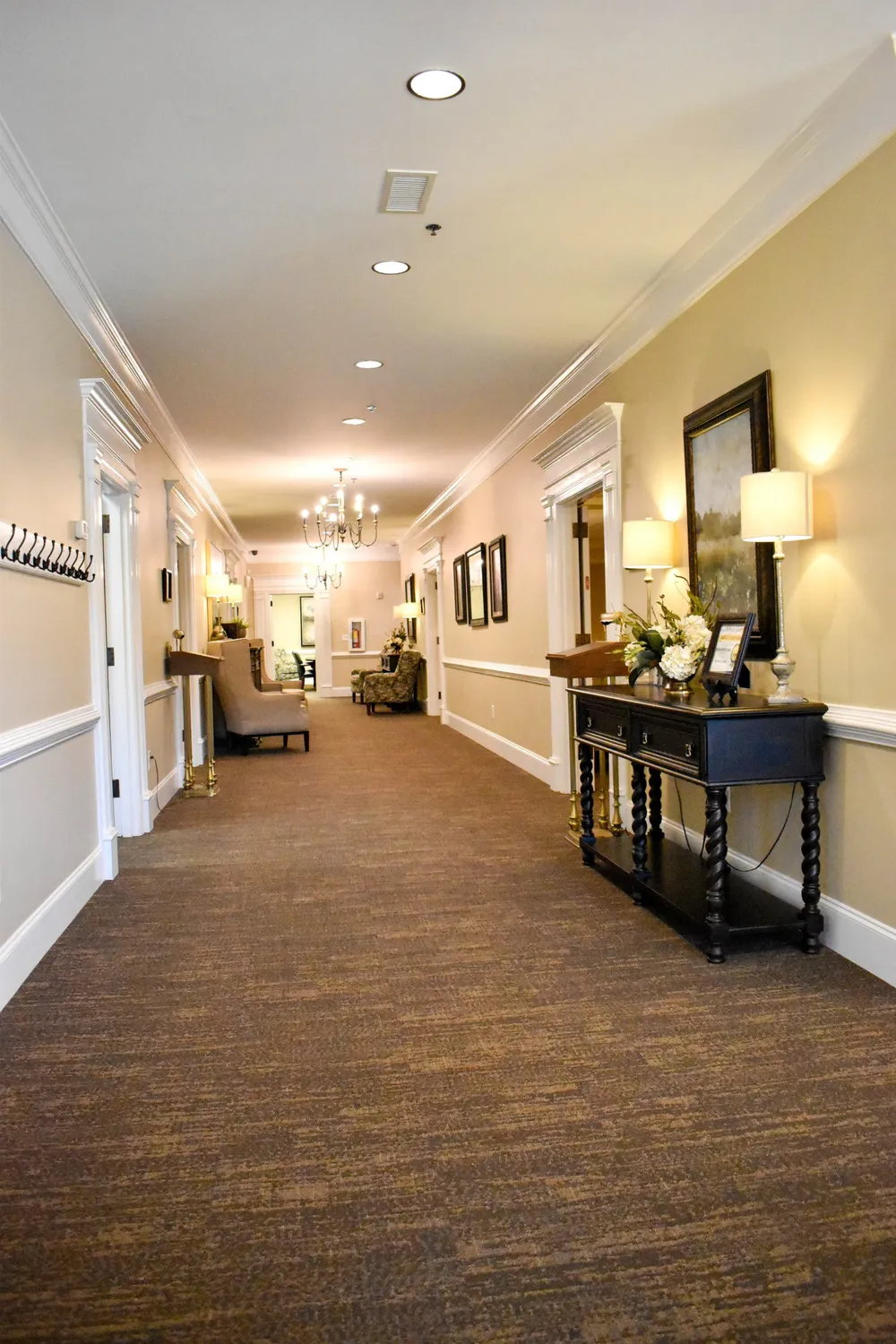 A long hallway with a table and chairs in it.