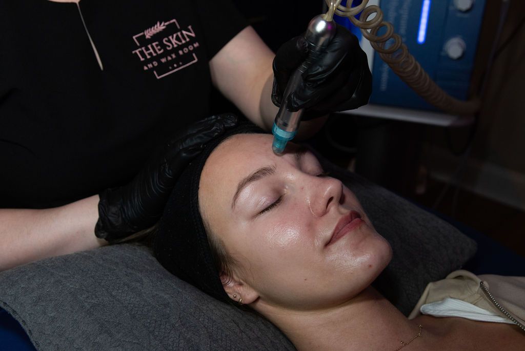 A woman is smiling and touching her face with her hands.