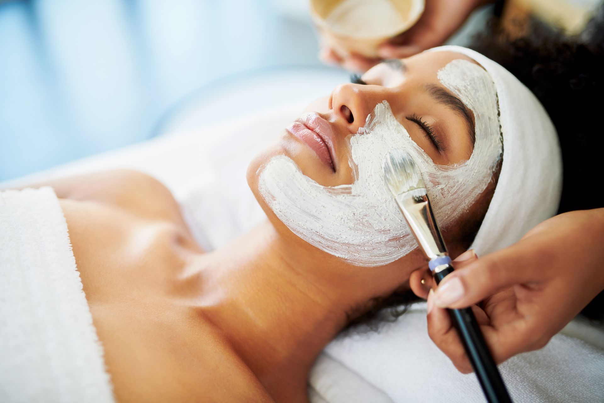 A woman is getting a facial treatment at a spa.