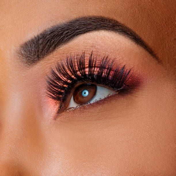 A close up of a woman 's eye with long eyelashes and eyebrows.