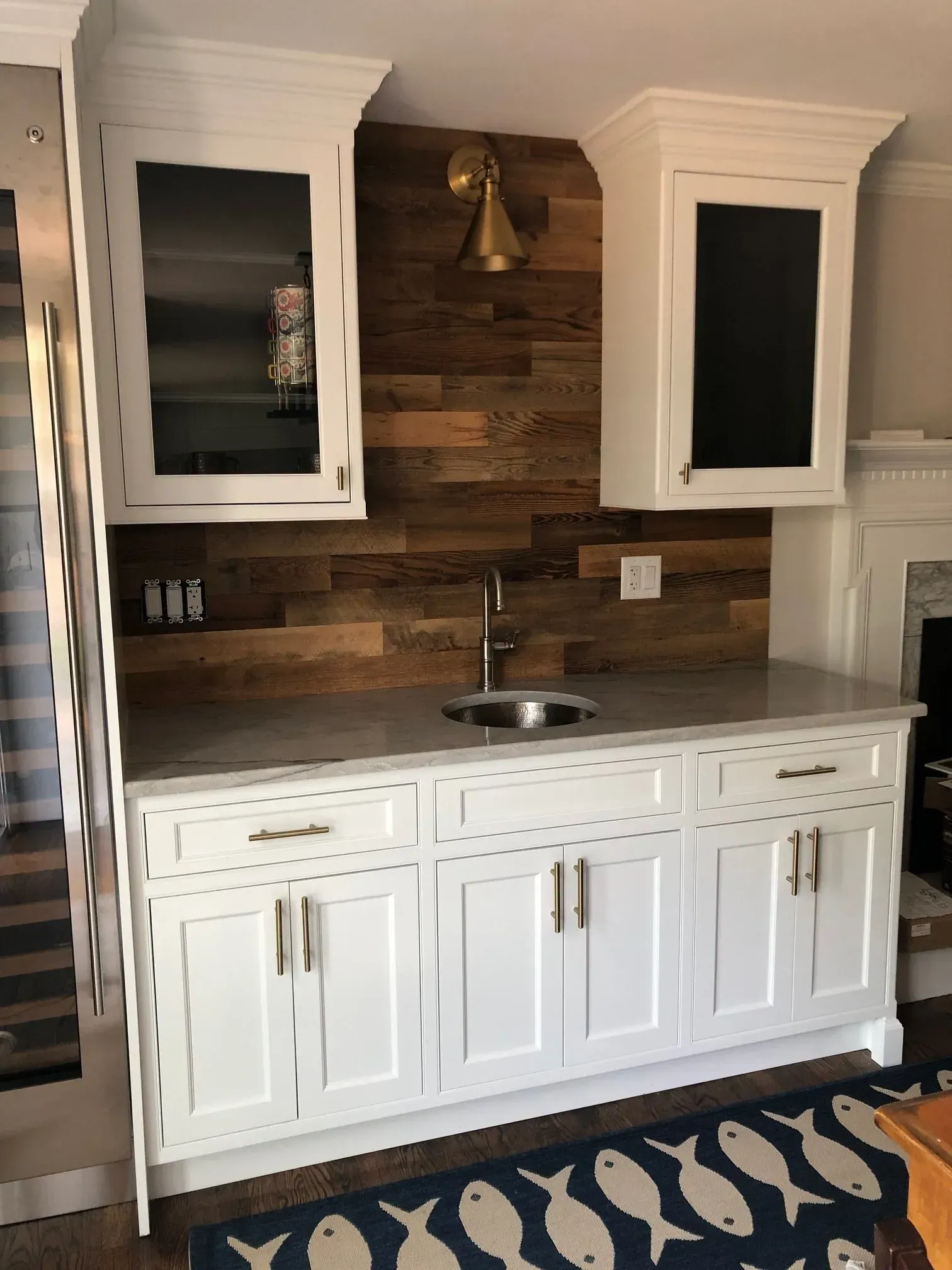 White cabinet bar with a wood backsplash, sink, and two wall cabinets.