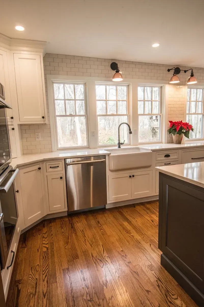 Kitchen with white cabinets, stainless steel appliances, and wood floors.
