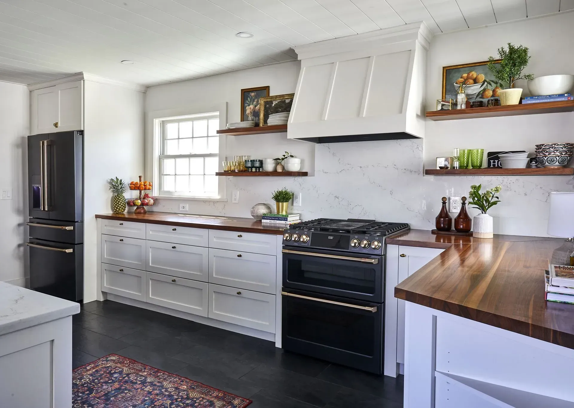 Kitchen with black appliances, white cabinets, and wooden countertops; dark wood floor, open shelving.
