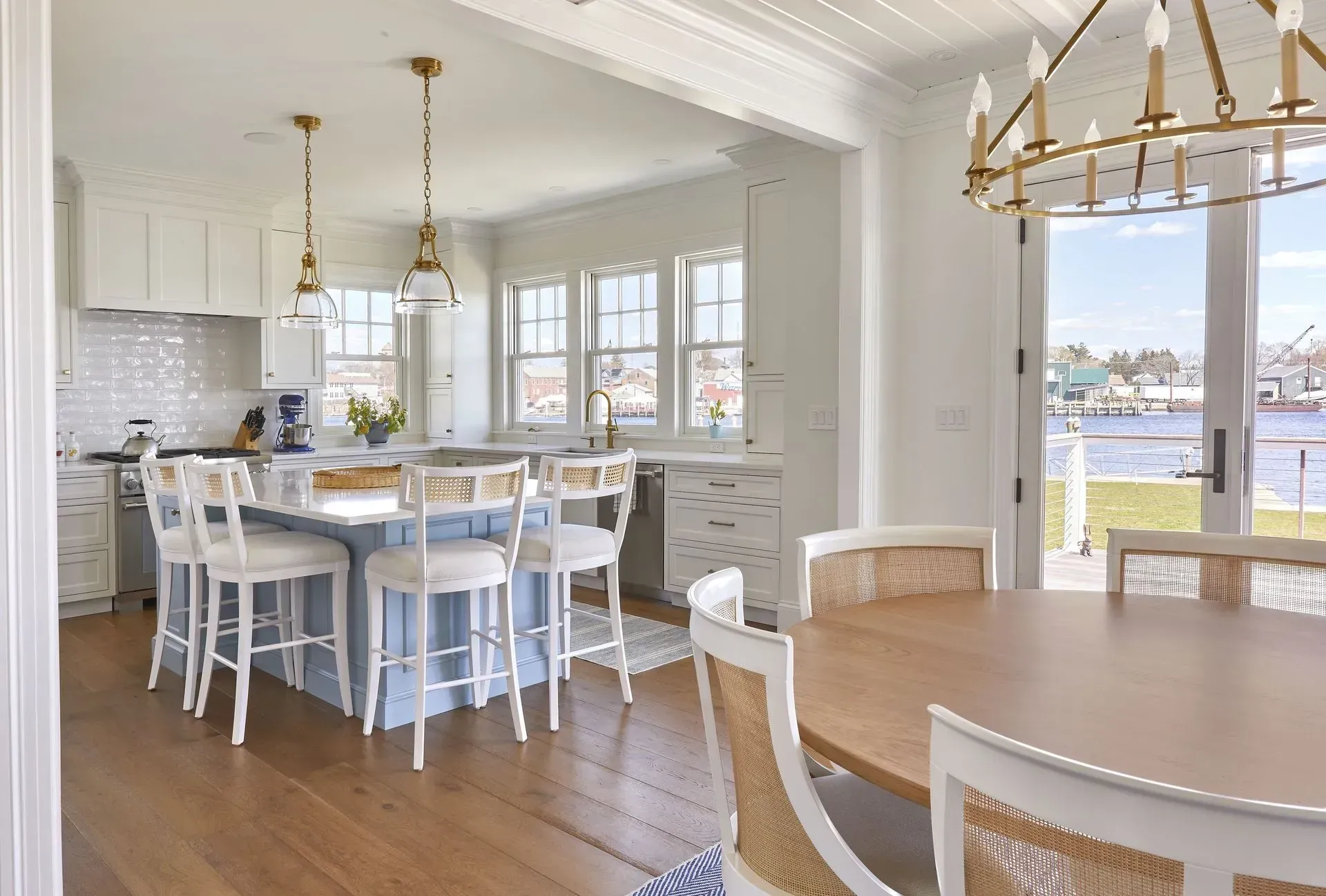 Kitchen with blue island, white cabinets, and water view.