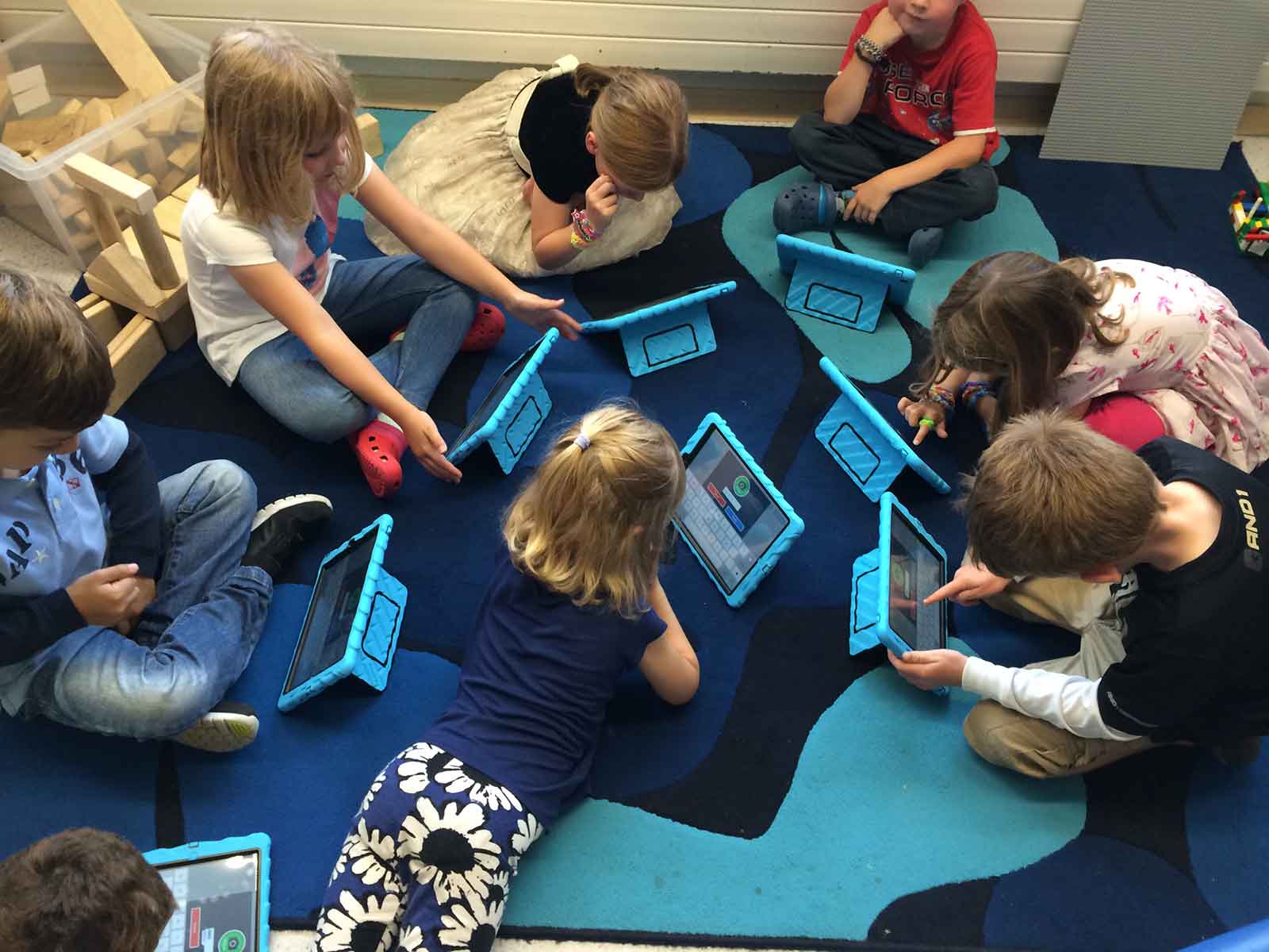 Children look on touch screen devices to learn.