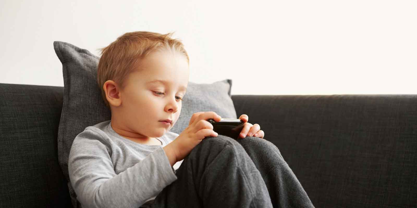 Developing Fine Motor Skills: A Boy looks at the screen of a smartphone.
