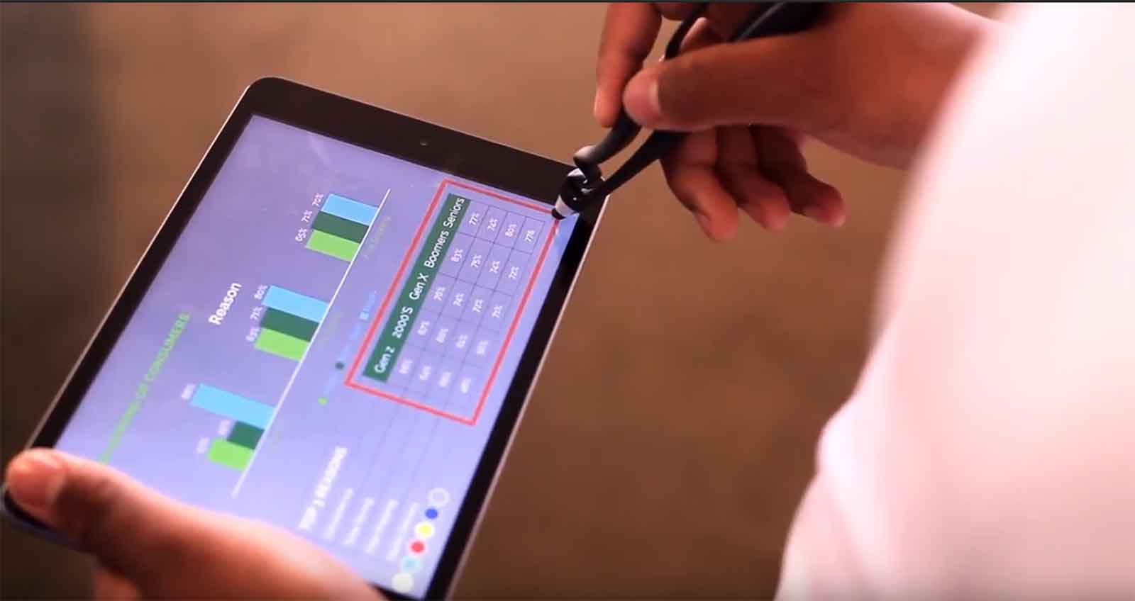 A person navigating a tablet with the use of the Scriba stylus.