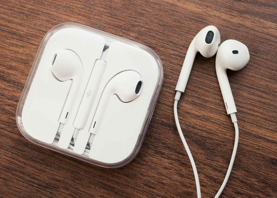 Two sets of apple earphone on a wooden table.