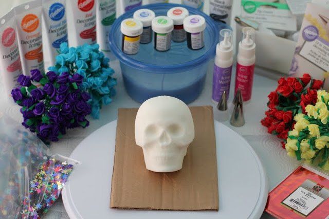A plastic skull surrounded by art materials