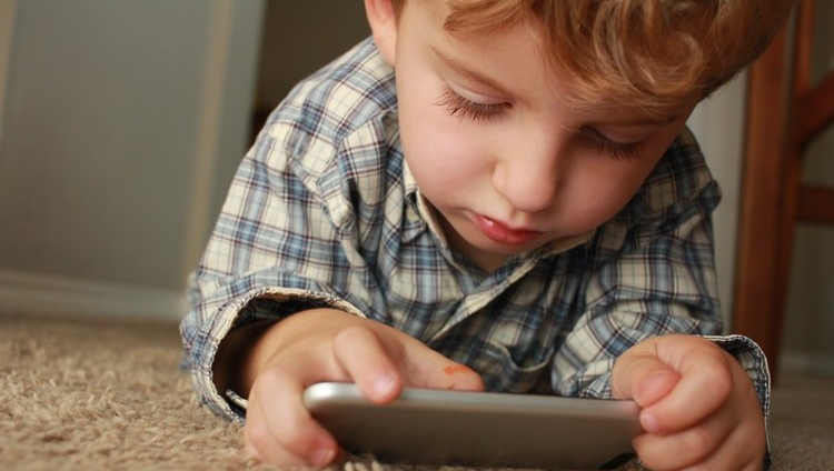 Young boy playing on mobile device