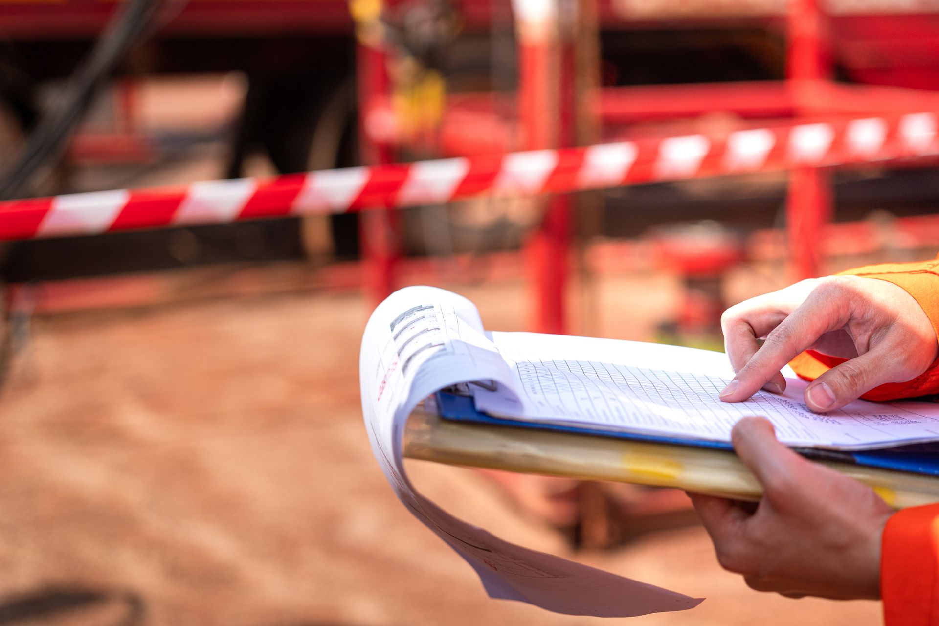 A person is holding a notebook and a piece of paper in their hands.
