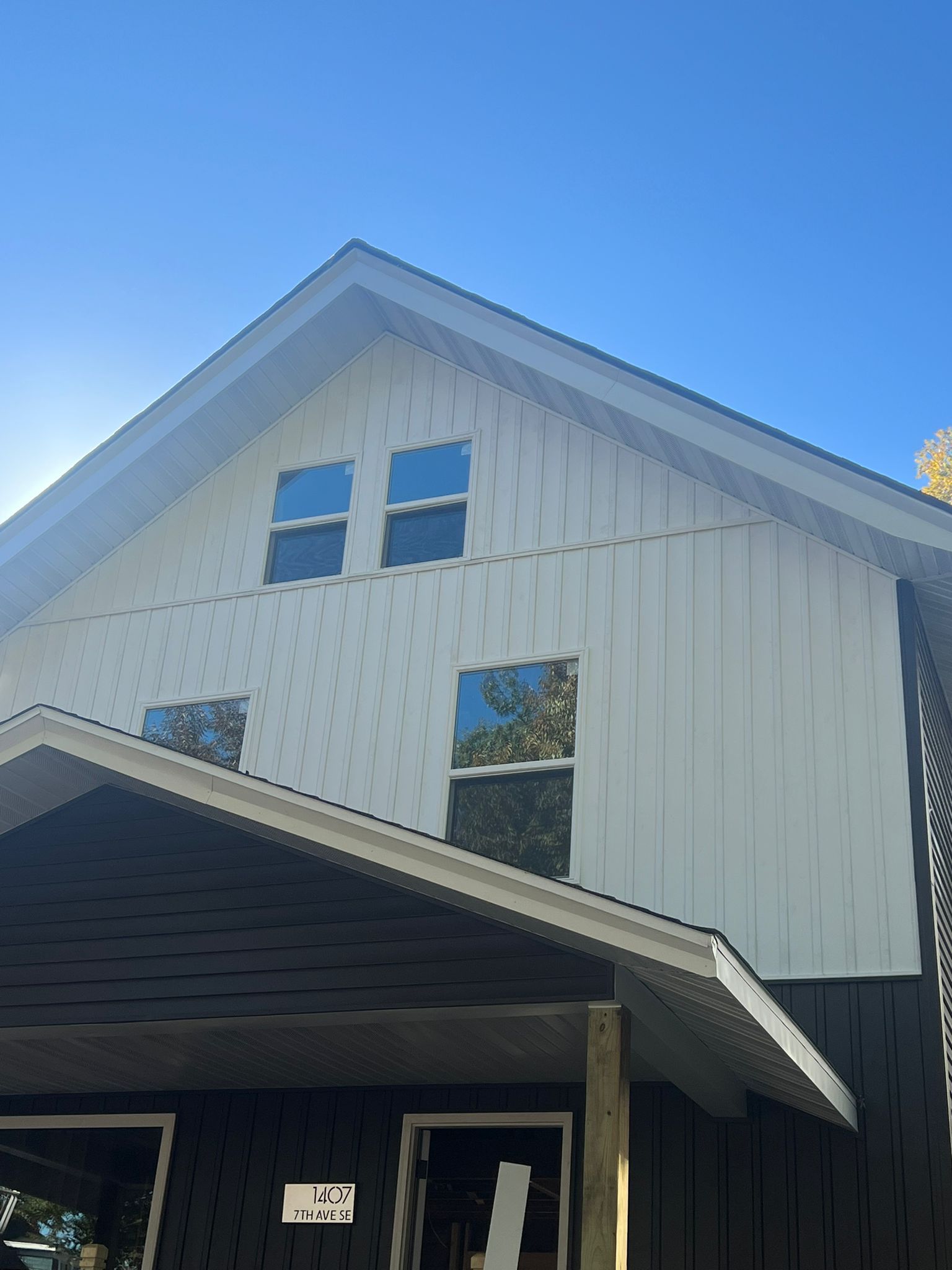 A black and white house with a blue sky in the background.