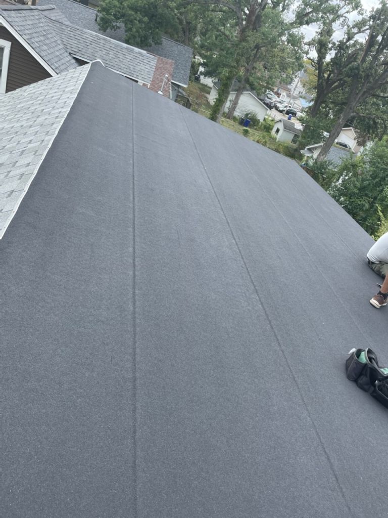 A man is working on the roof of a house.
