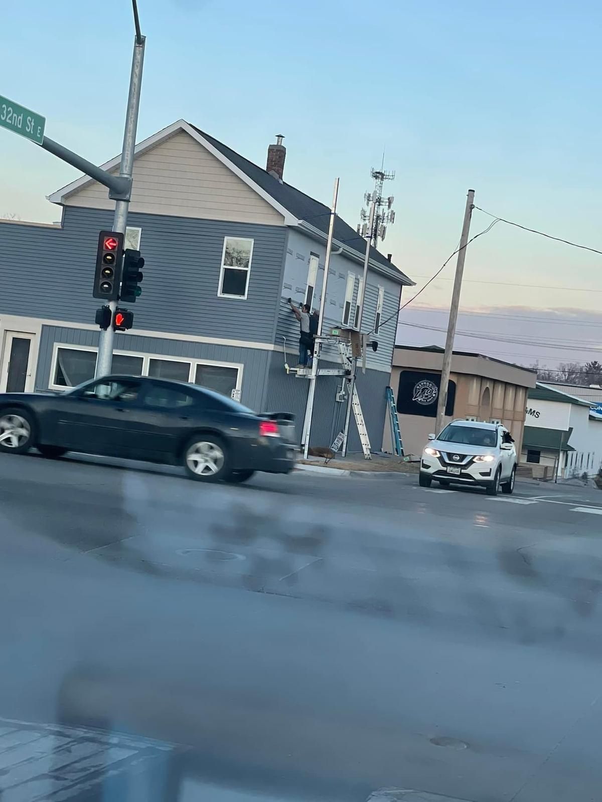 A car is driving down a street in front of a building.
