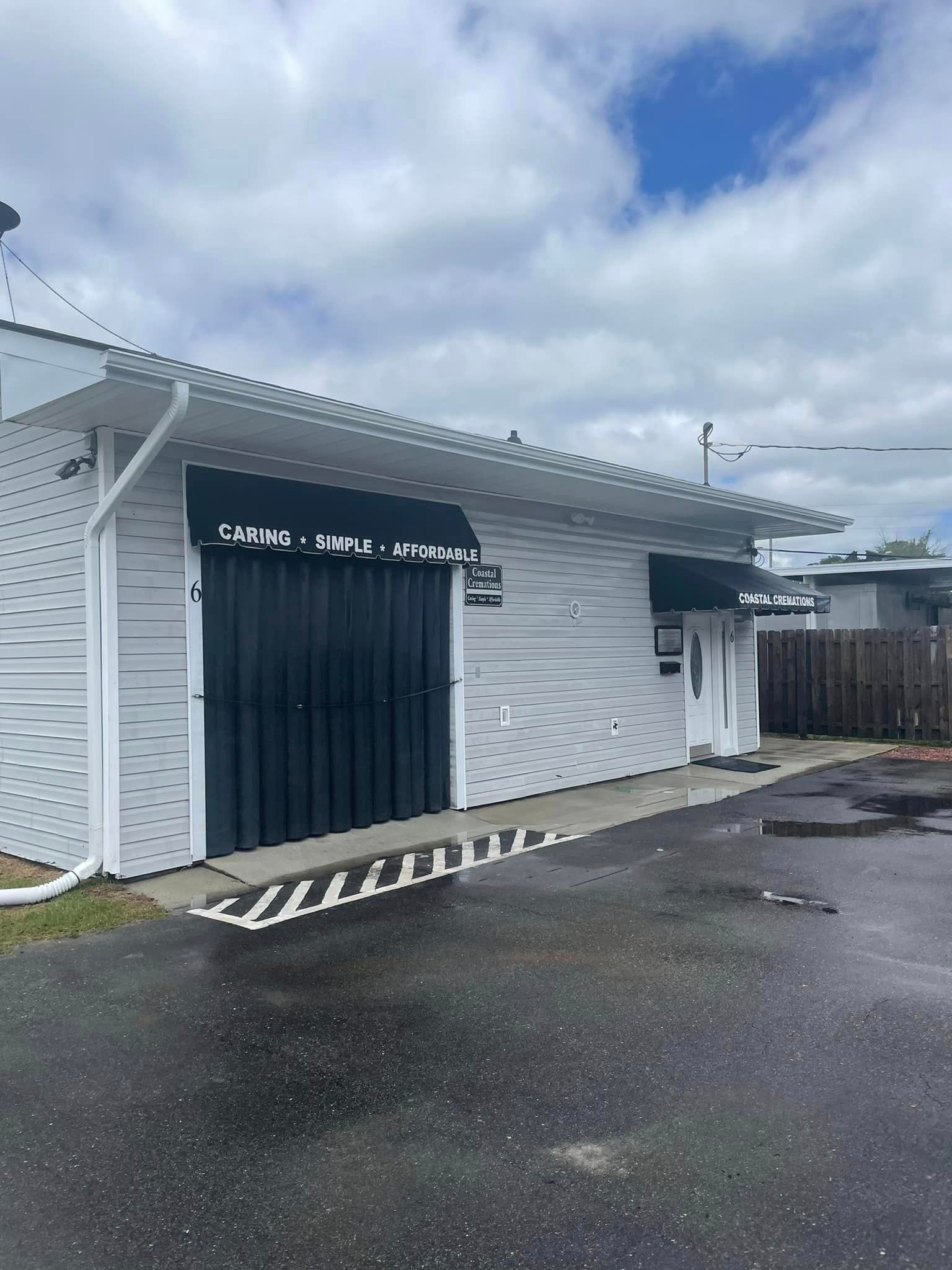 A White Building With A Black Garage — Leland, NC — Coastal Exterior Solutions