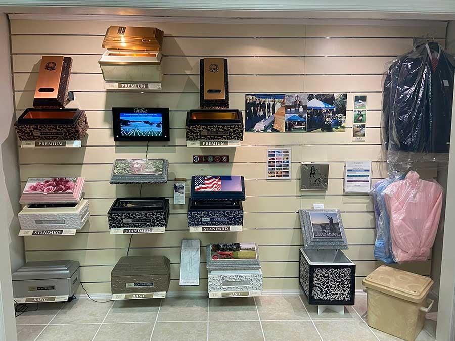 Display of various decorative mailboxes and clothing items on a wall.