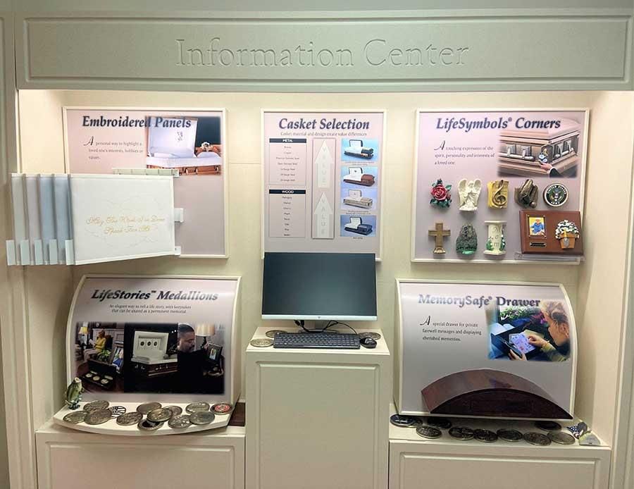 Information center display with funeral service options: caskets, urns, and memorial accessories.
