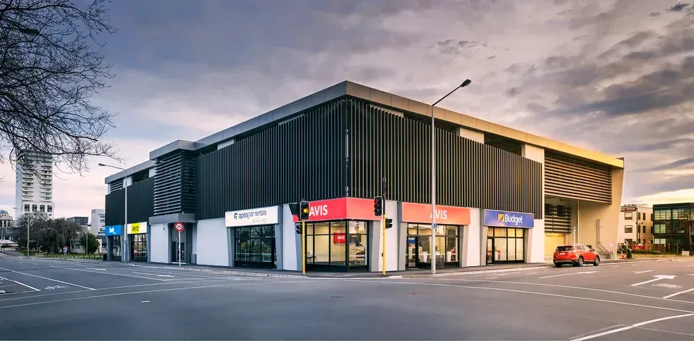 Longhurst Health building with illuminated windows; cloudy sky.