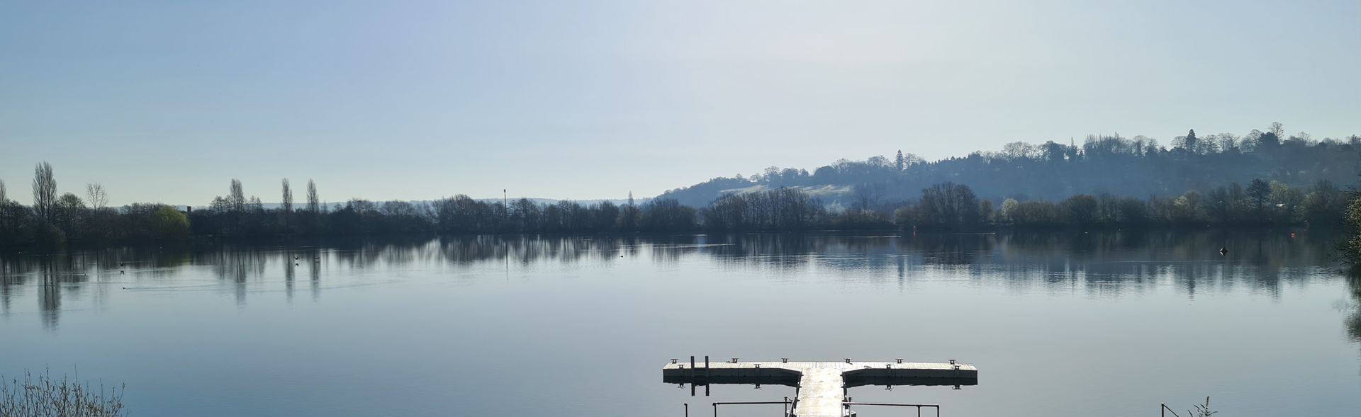 A lake with a dock in the middle of it