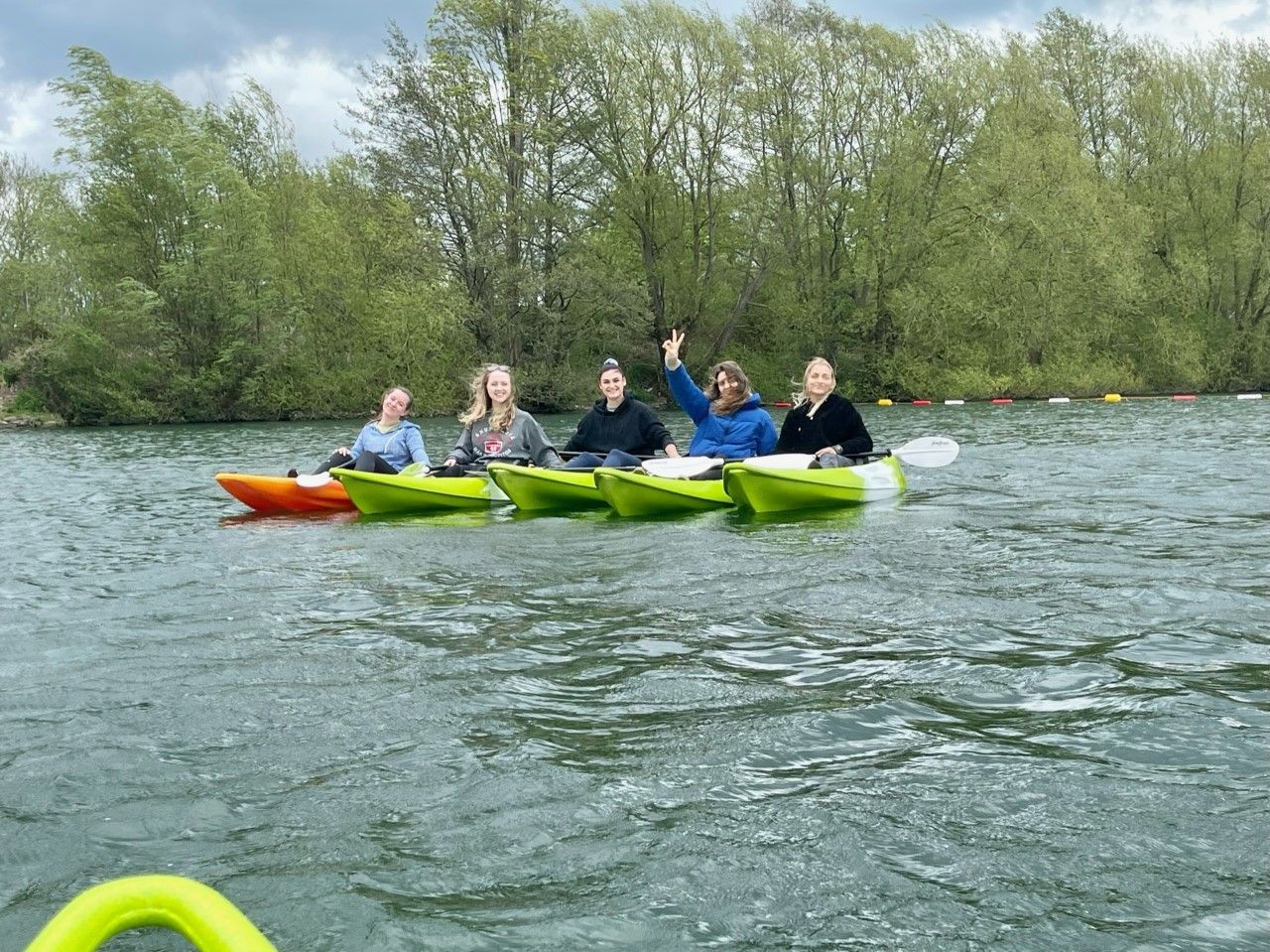 A group of people are rowing kayaks on a lake.
