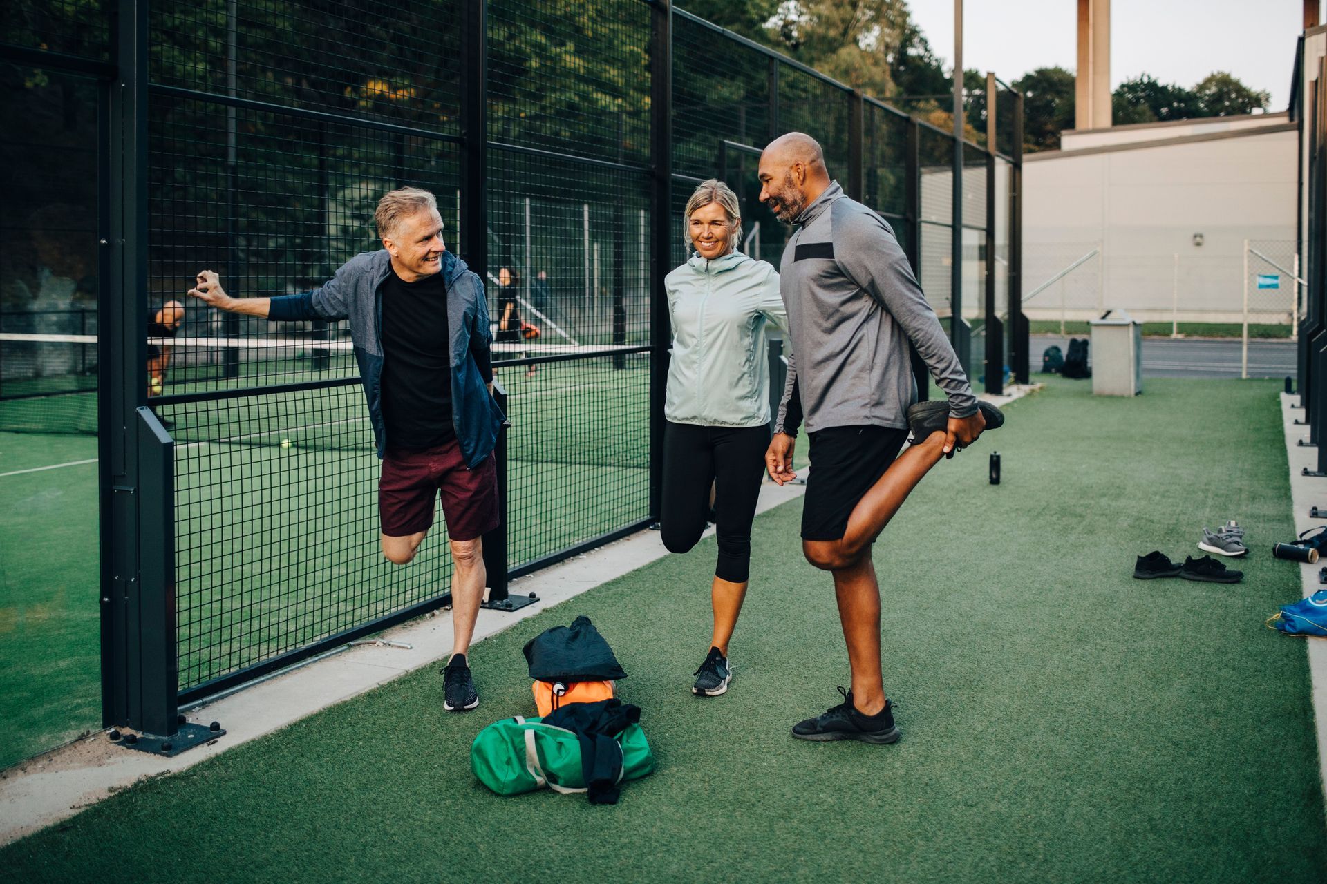 A group of women are doing stretching exercises in a park.
