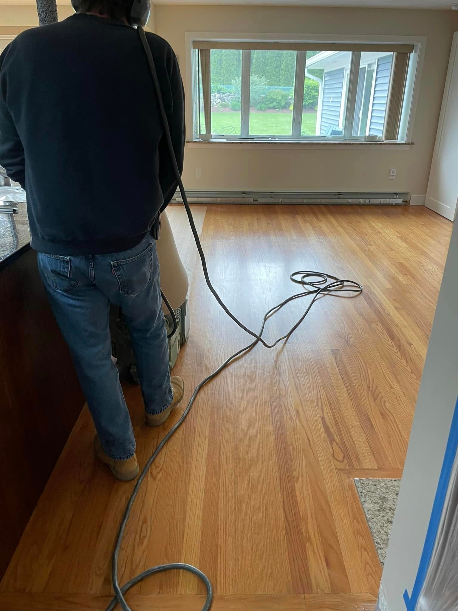 A man is standing in a living room with a vacuum cleaner.