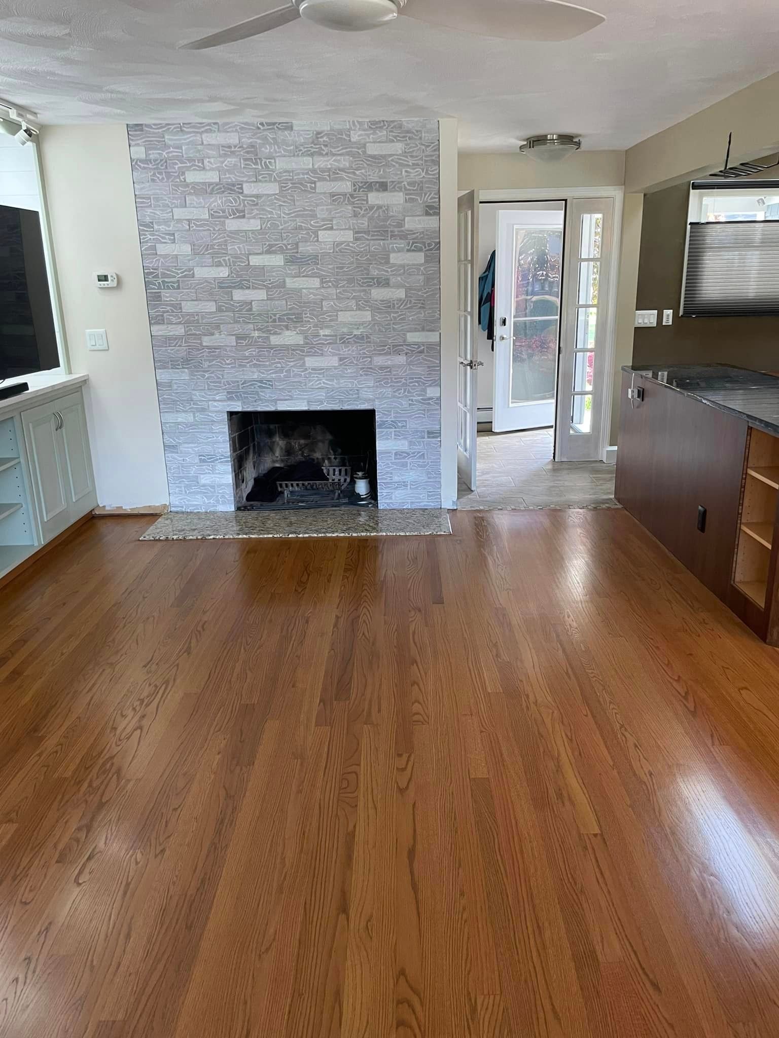 A living room with hardwood floors and a fireplace.