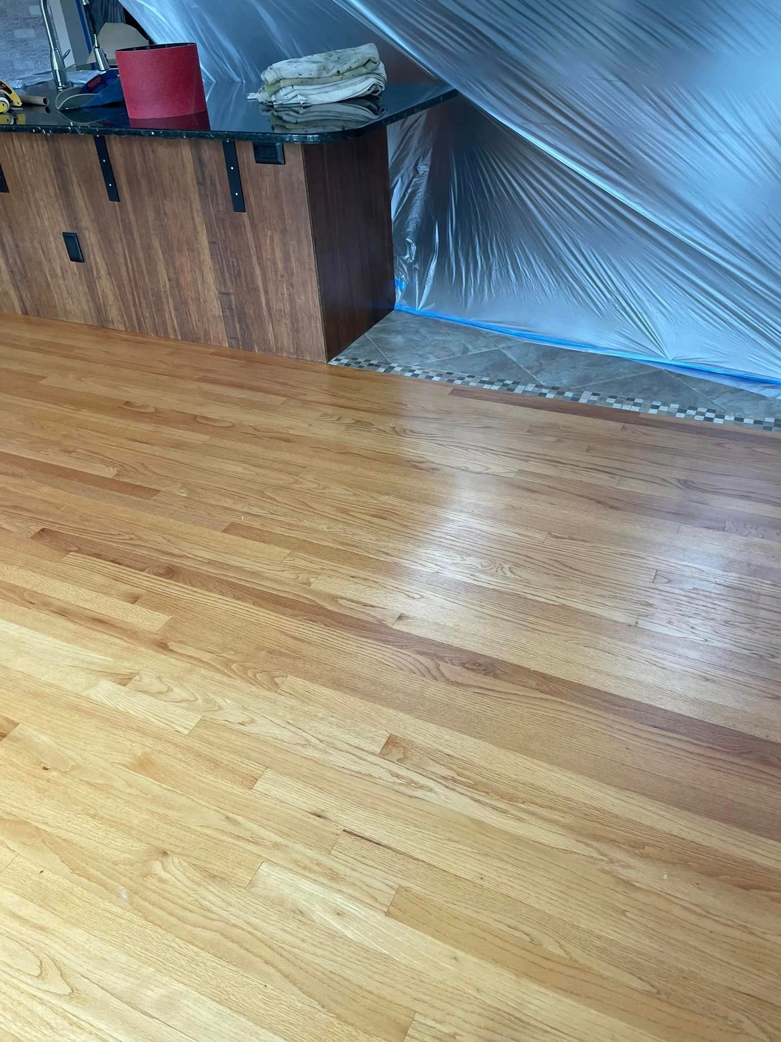 A room with a wooden floor and a table covered in plastic.