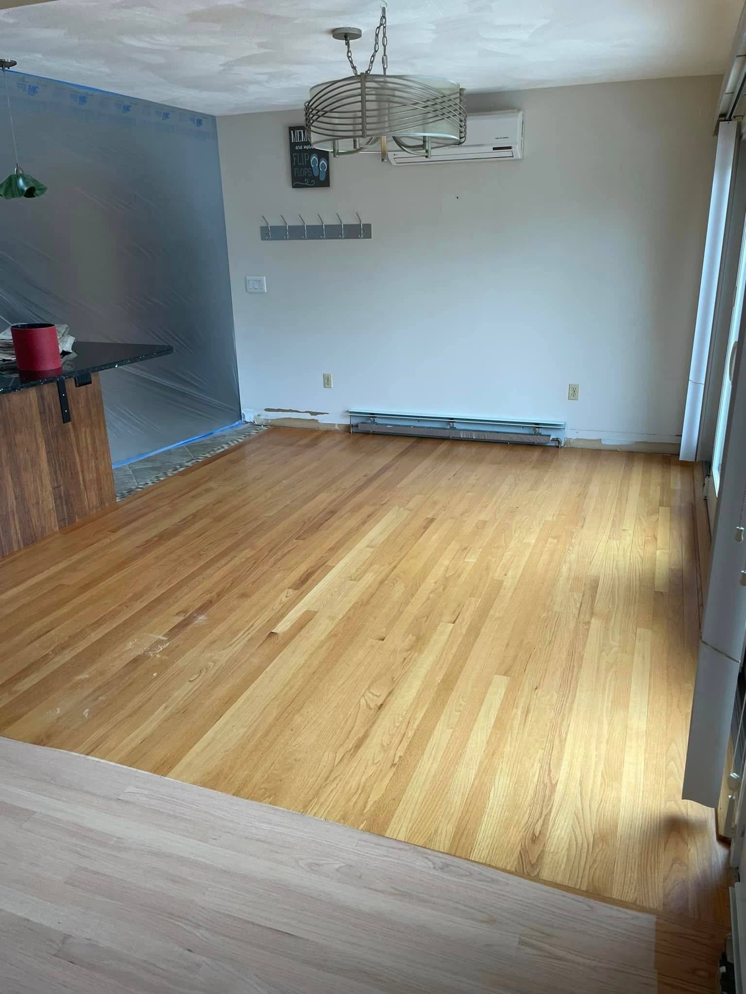A living room with hardwood floors and a chandelier.