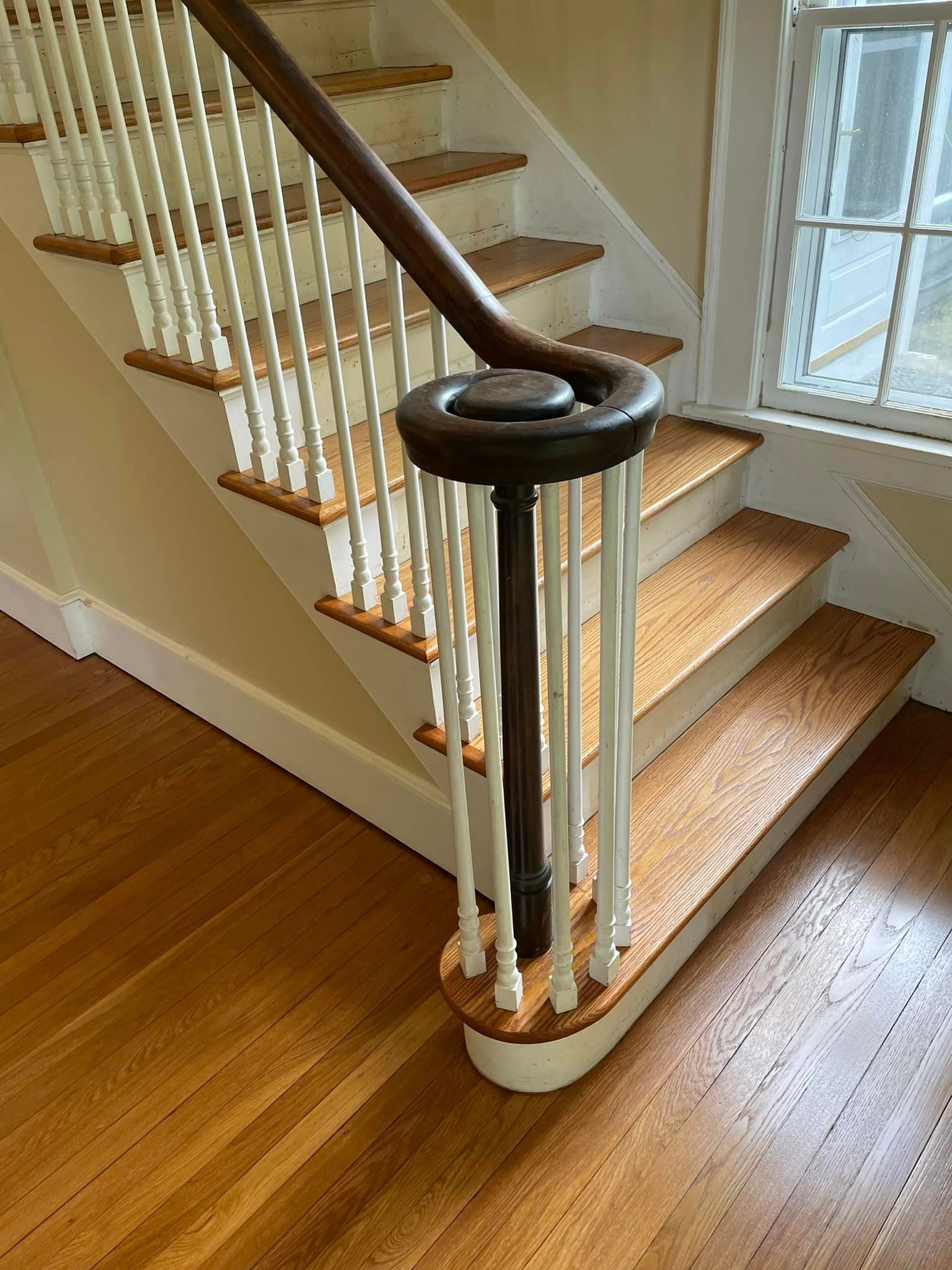 A staircase with wooden steps and white railings in a house.