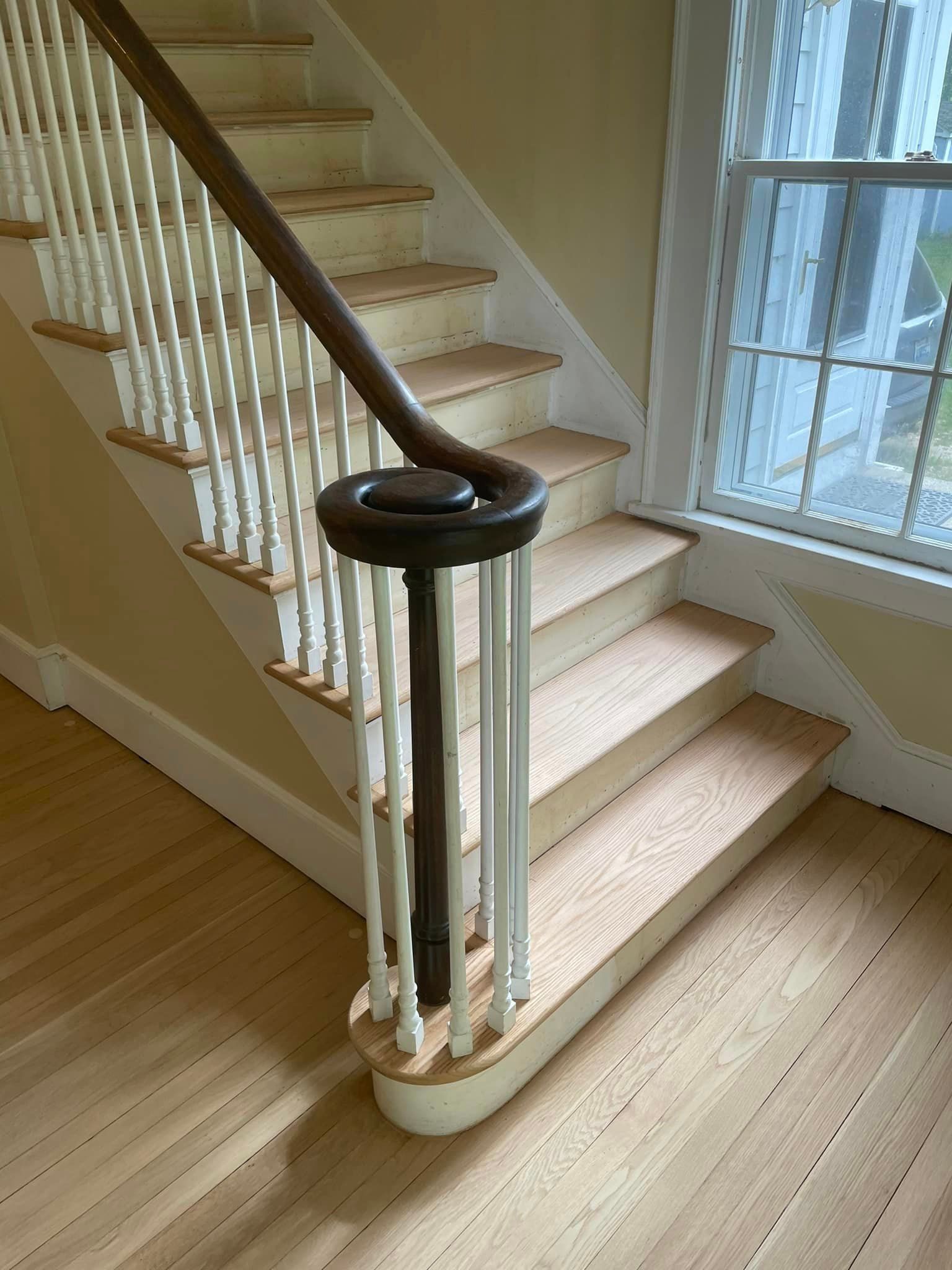 A staircase with wooden steps and a wooden railing in a house.