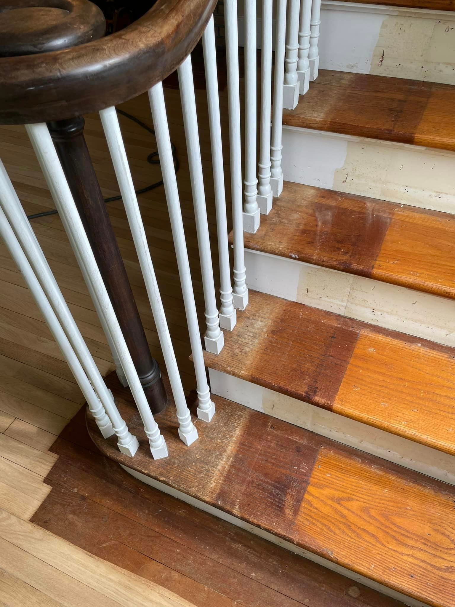 A close up of a wooden staircase with white railings.