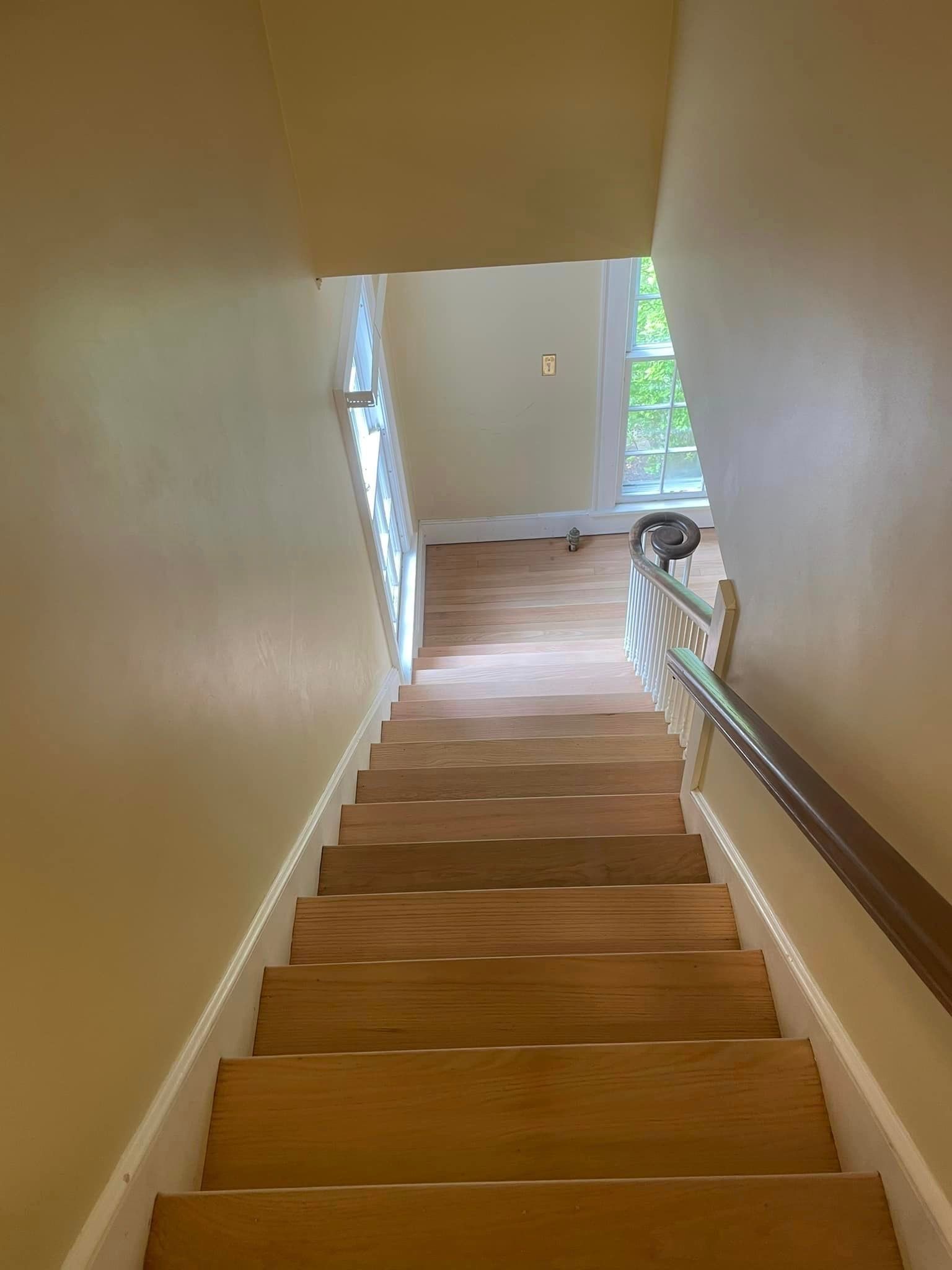 A set of wooden stairs leading up to the second floor of a house.