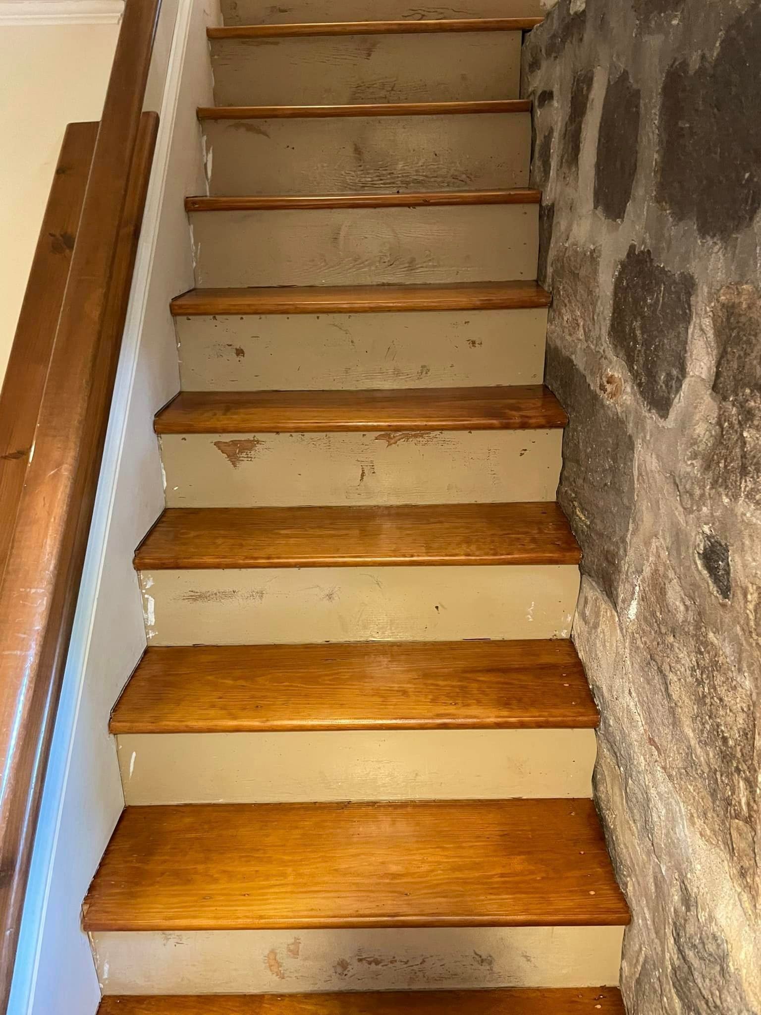 A set of wooden stairs leading up to a stone wall