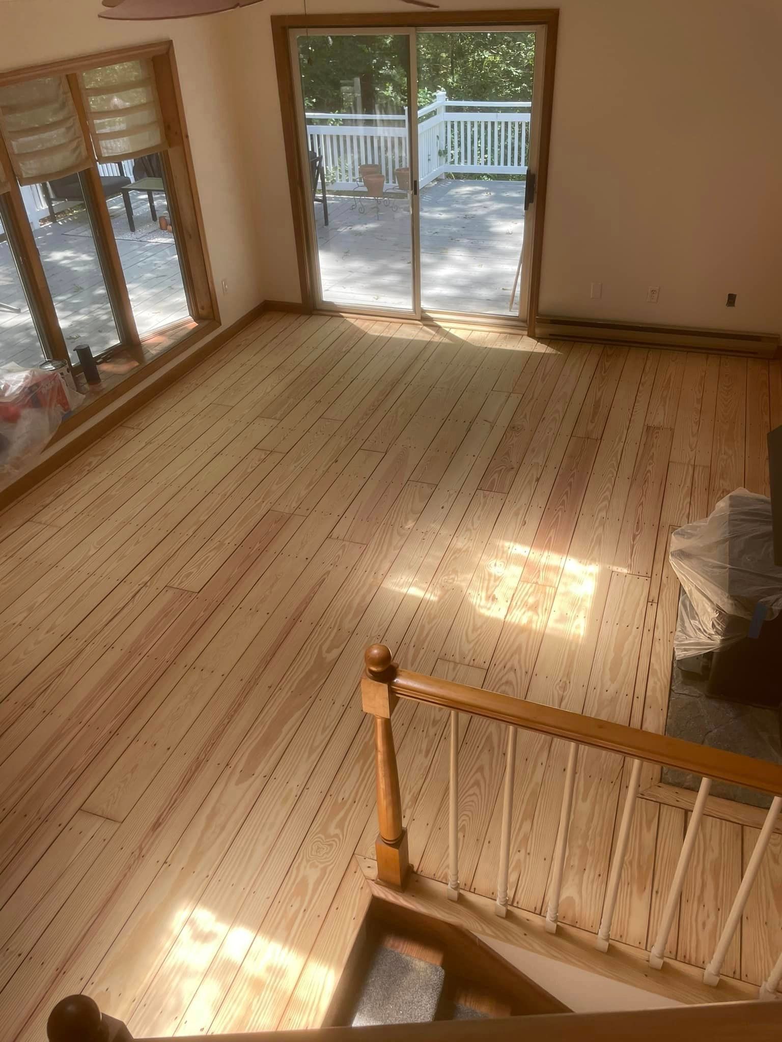 An aerial view of a living room with a wooden floor and stairs.