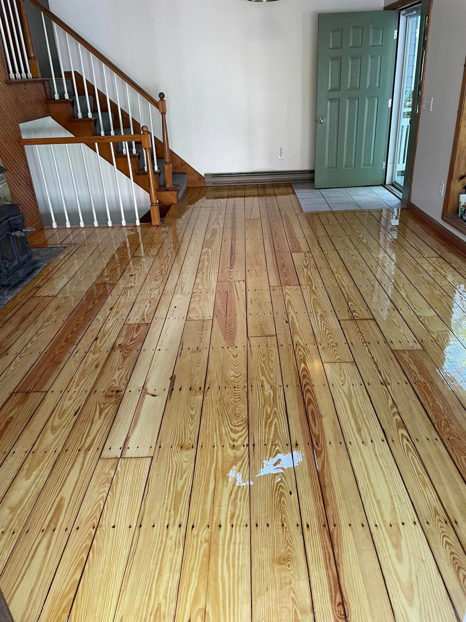 A living room with a wooden floor and stairs.