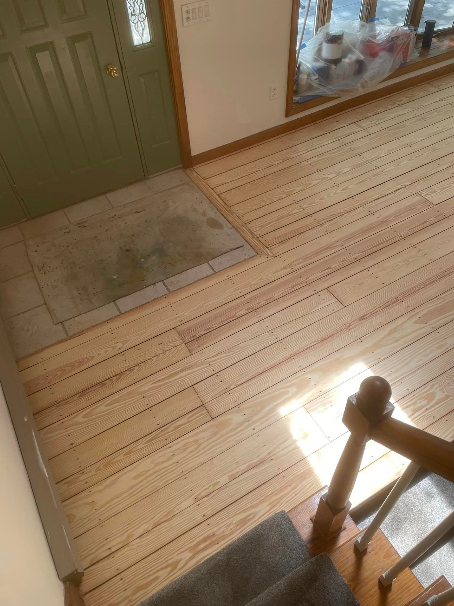 An aerial view of a wooden floor and stairs in a house.