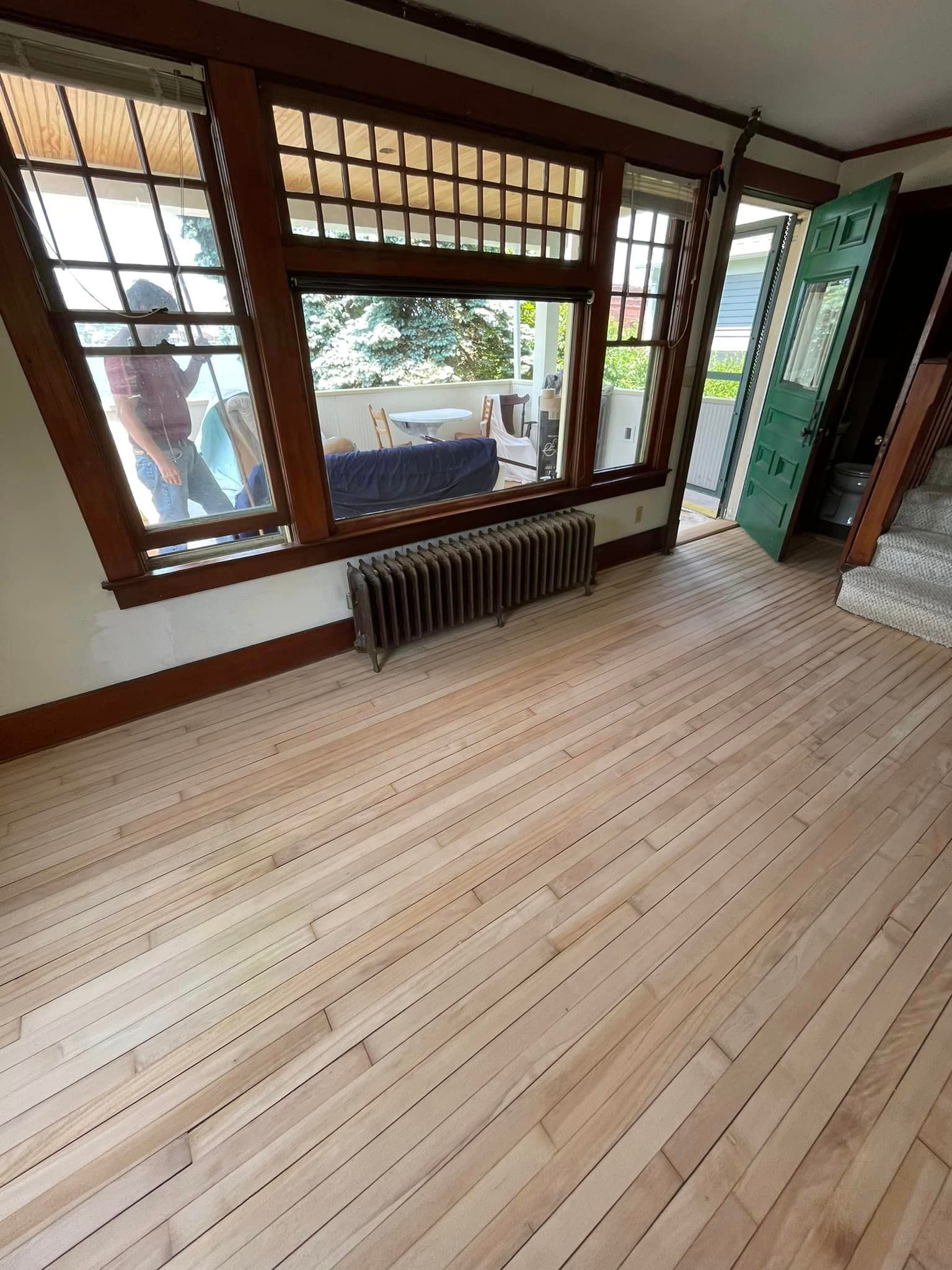 A living room with hardwood floors and a radiator.