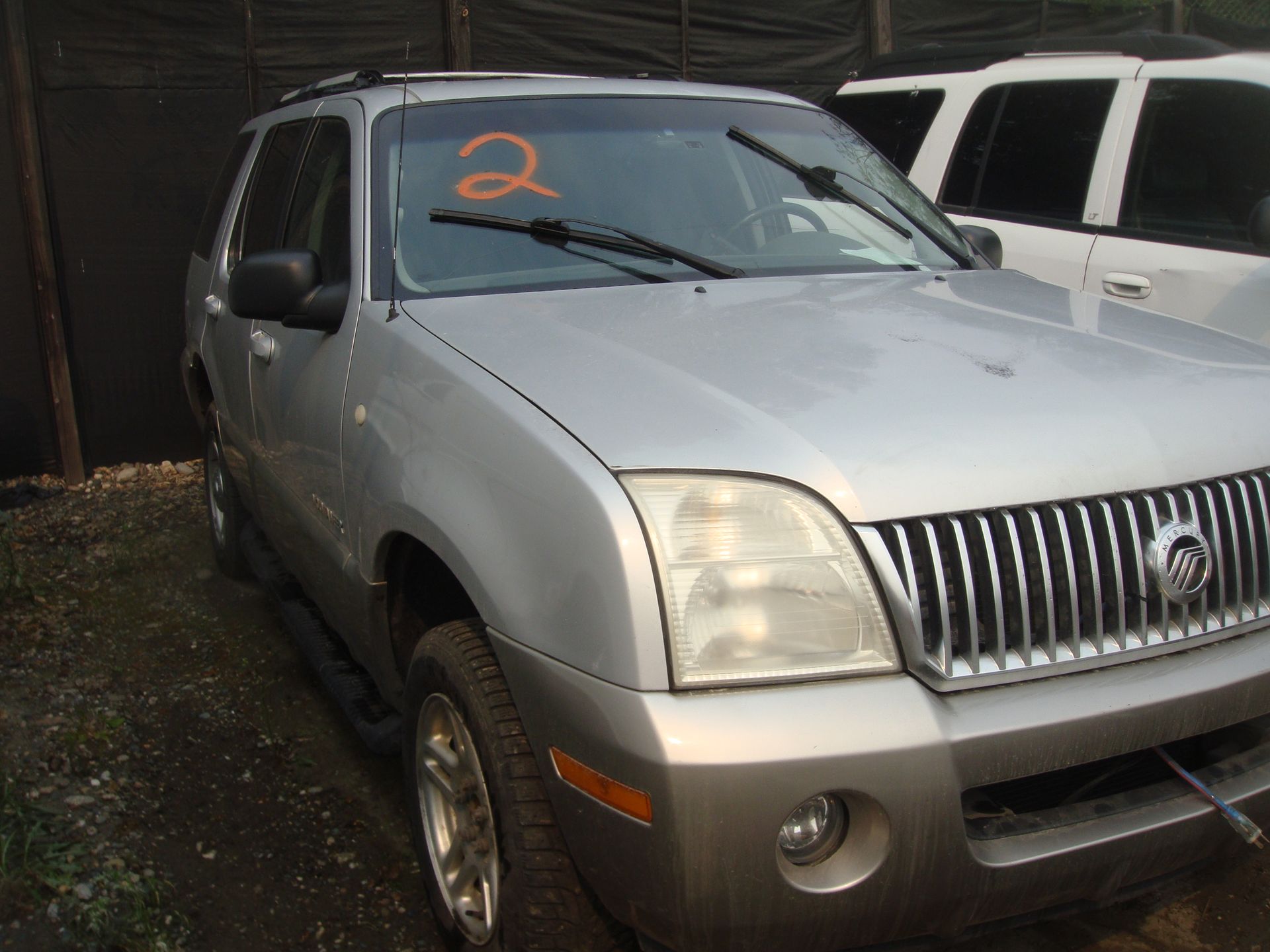A silver suv with the number 2 on the windshield
