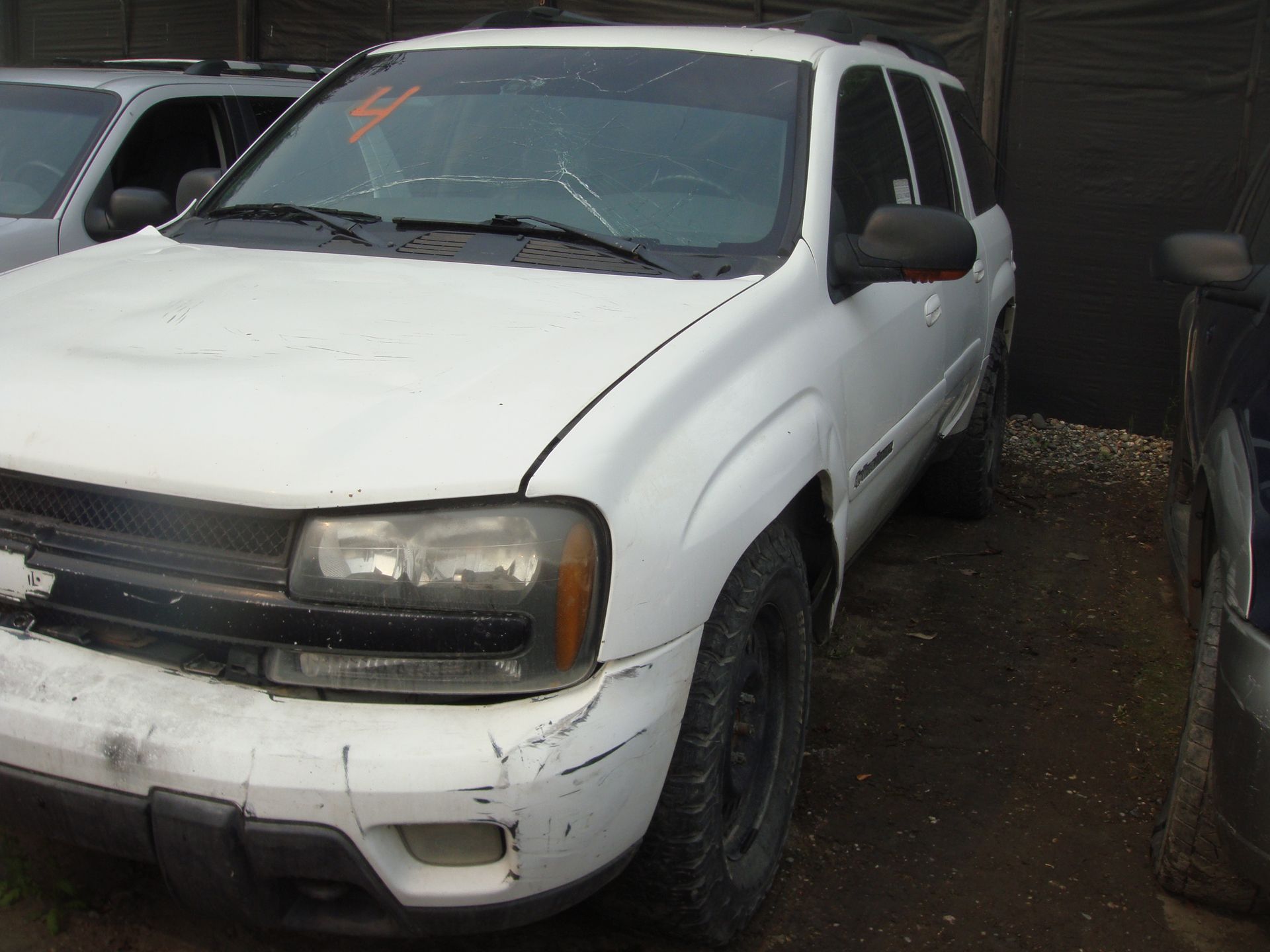 A white chevrolet trailblazer is parked in a lot