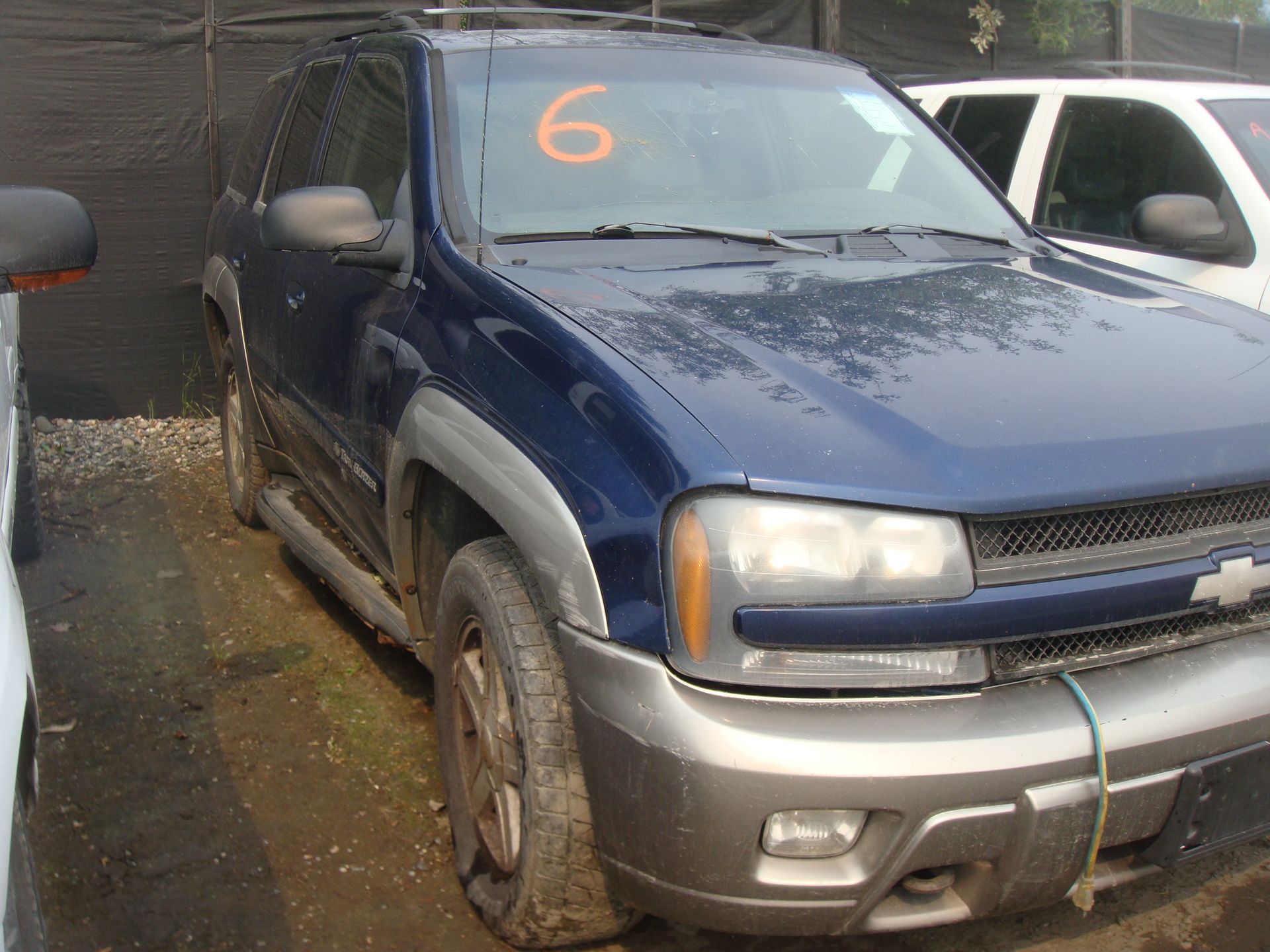 A blue suv with the number 6 on the windshield