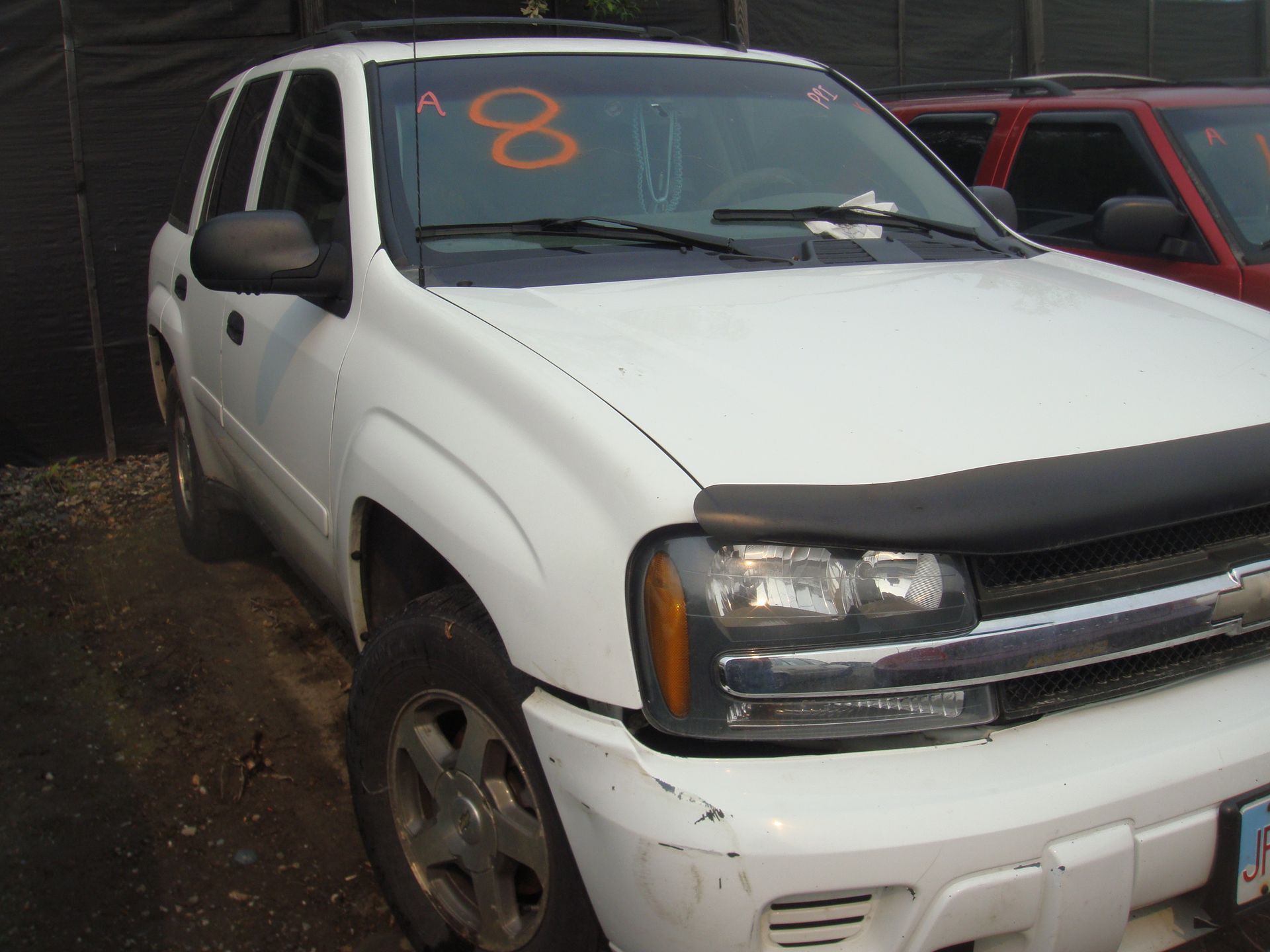 A white suv with the number 8 on the windshield
