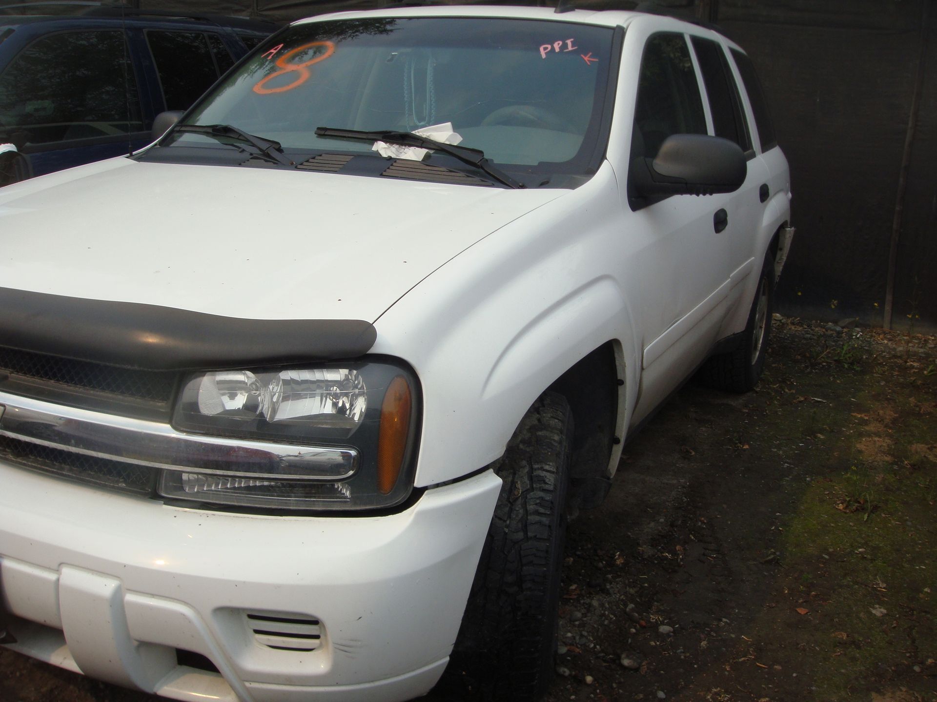 A white chevrolet trailblazer is parked in a lot