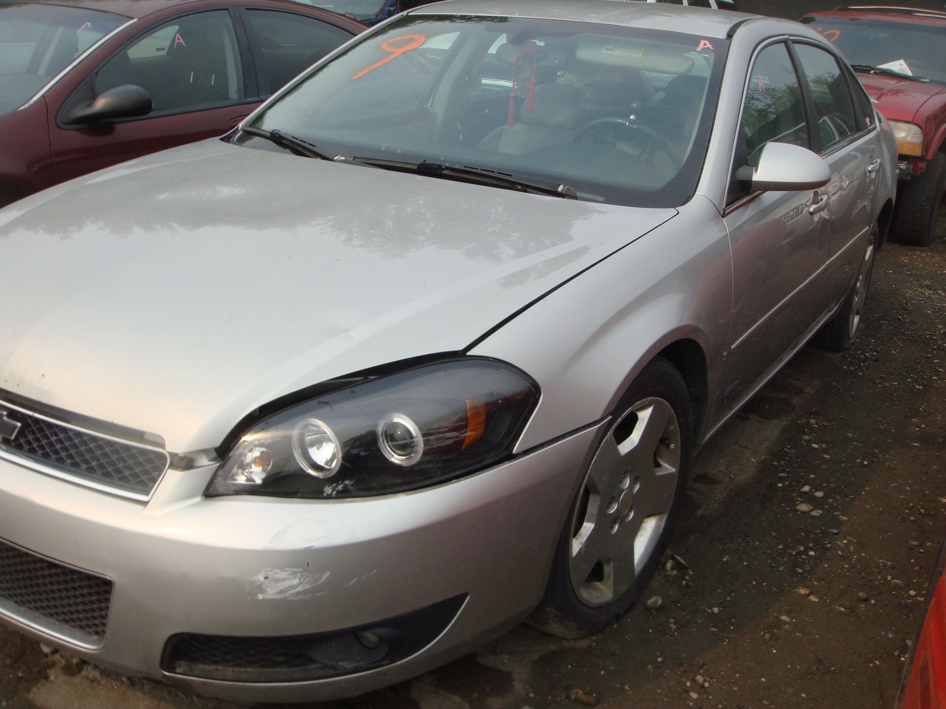 A silver car is parked in a lot with other cars