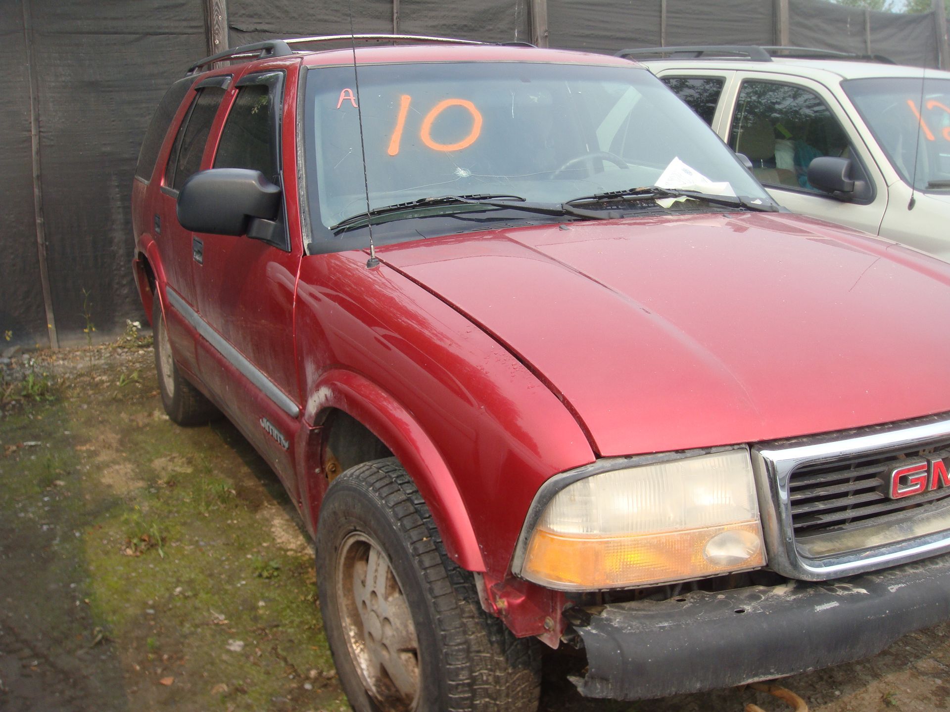 A red gmc sierra with the number 10 on the windshield