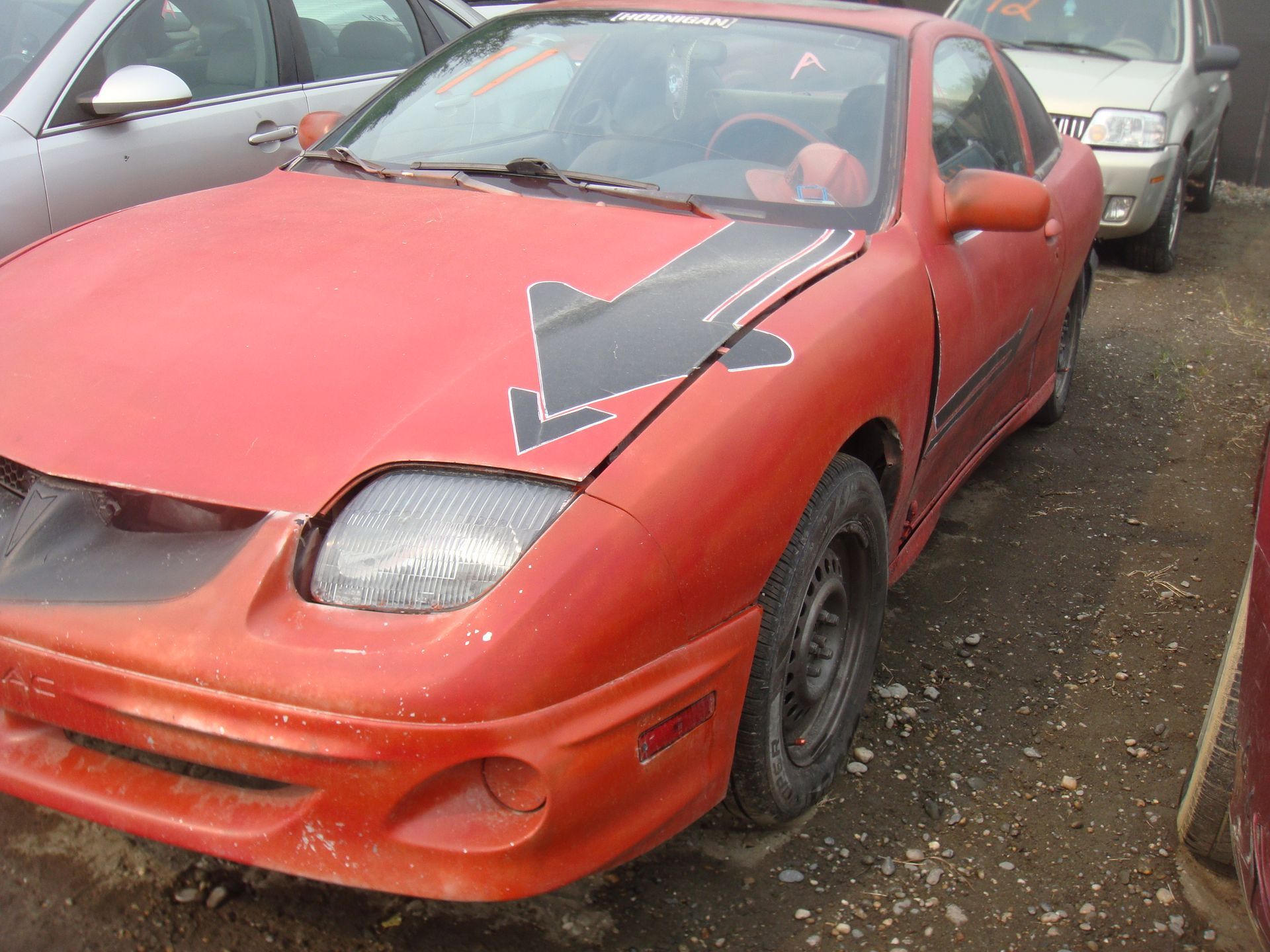 A red car with a black arrow on the hood