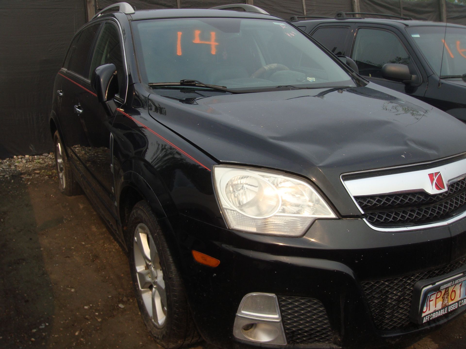 A black car with the number 14 on the windshield