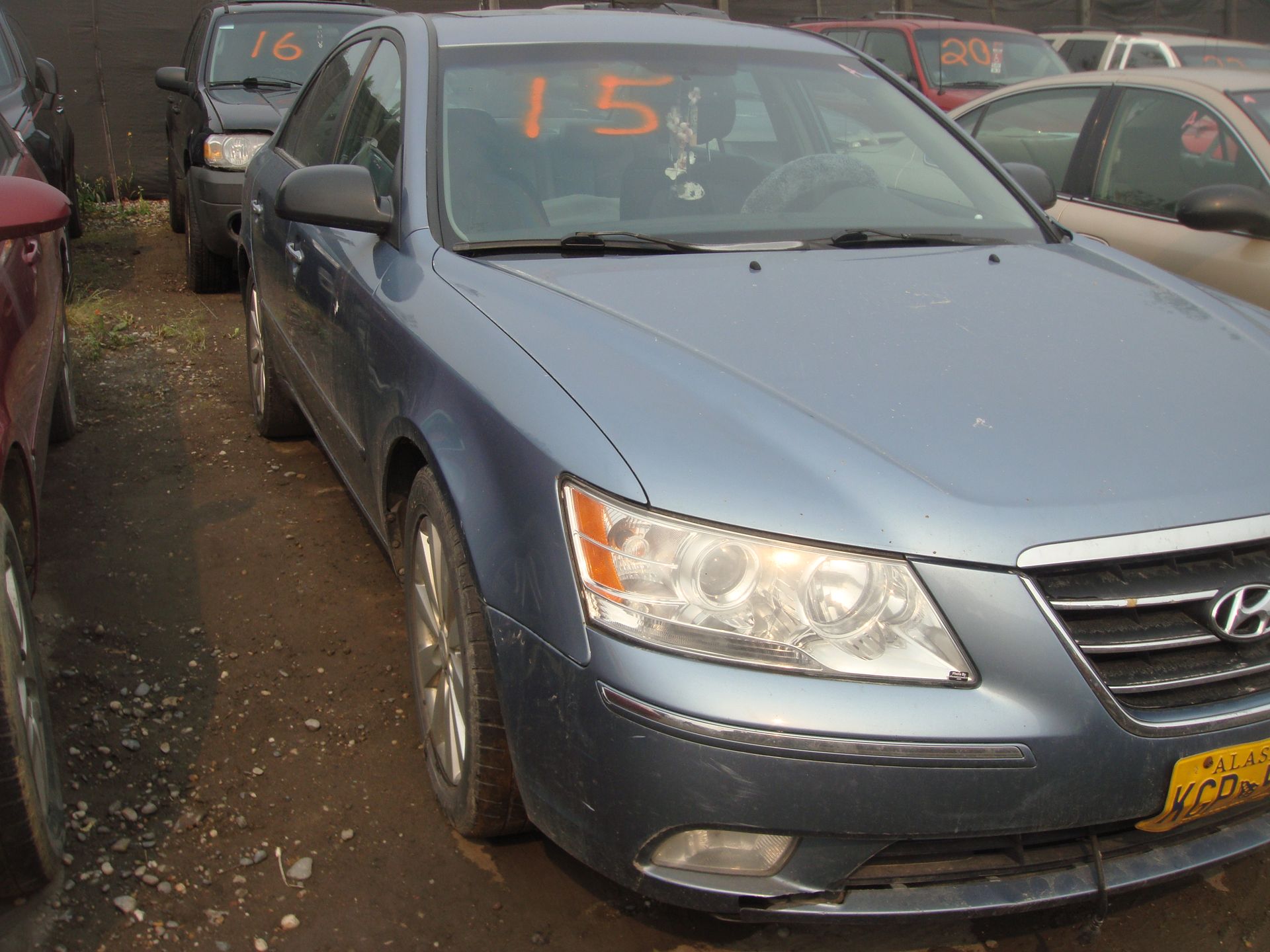 A blue car with the number 15 on the windshield